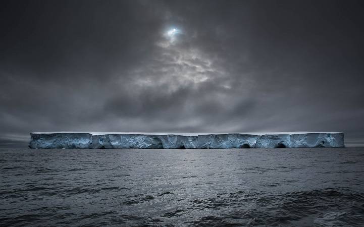 Last December i sailed to Antarctica on a 54 feet long-haul steel vessel . As we entered the Polar Zone this was one of the first icebergs we saw. Sculpted by the wind and waves, majestic in scale and with a dazzling white colour with layers of deep blue. The sun makes a quick appearance through a hole in the clouds, just in time for this shot.
